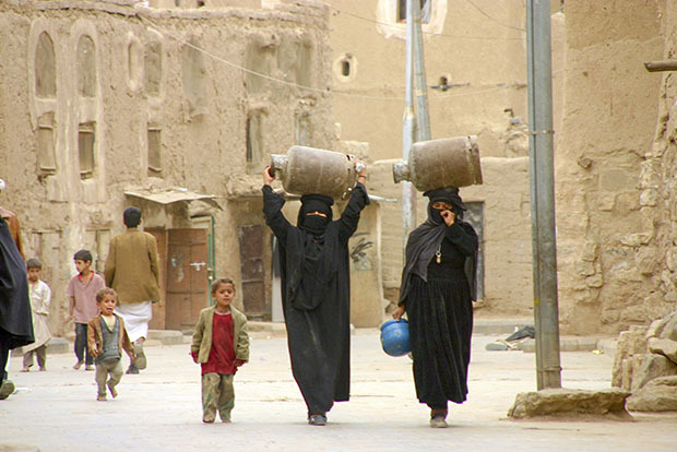 Two women carrying jugs on their heads
