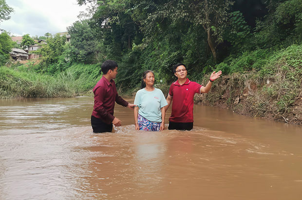 Two people baptizing a woman