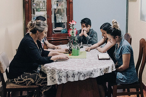 Liliana praying with her family